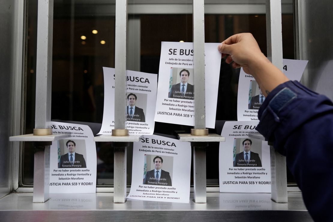 A demonstrator places a flyer outside Peru's Foreign Ministry building in Lima