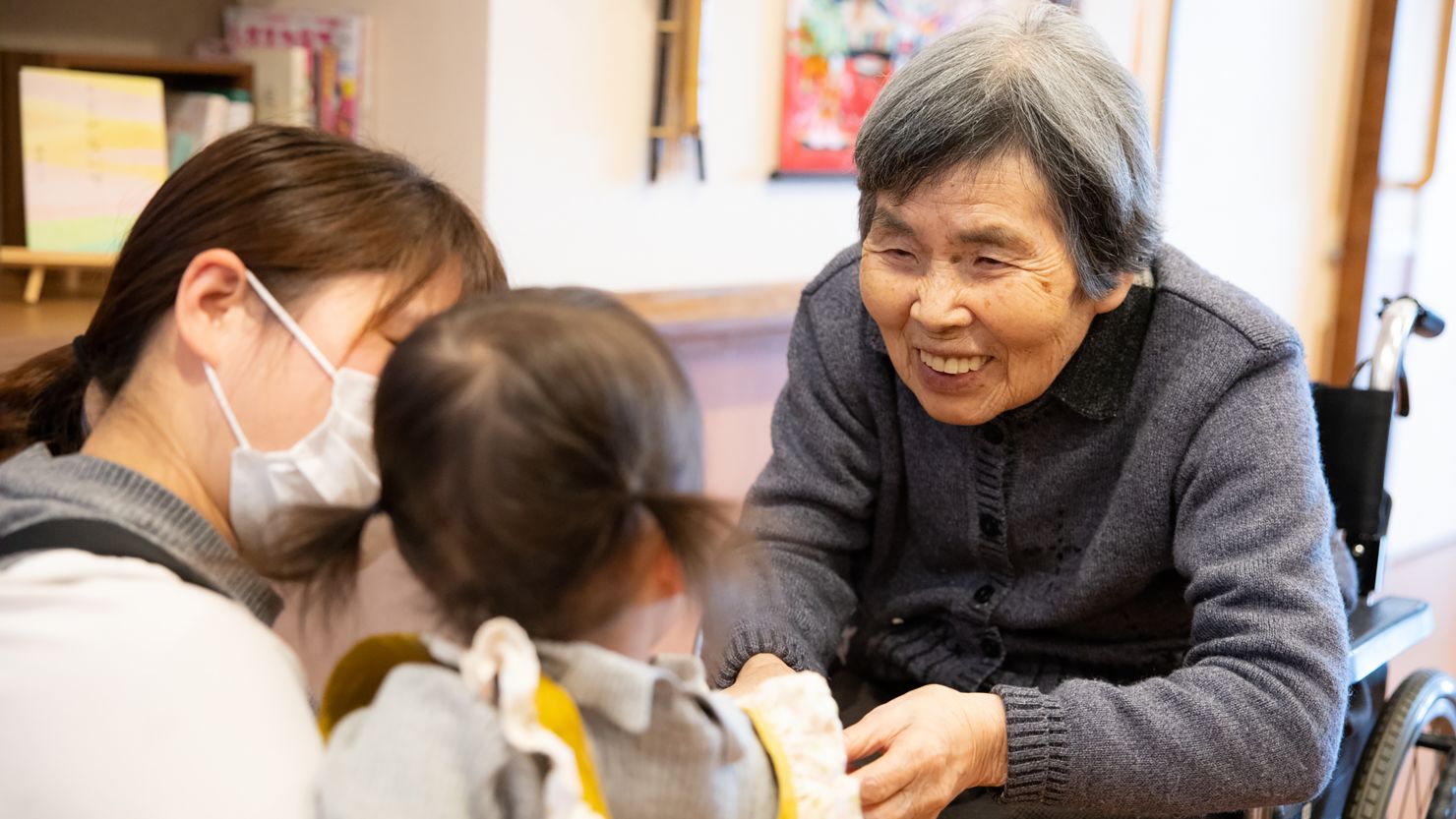 A resident meets a baby at the Moyai Seiyukai nursing home in Kitakyushu, Japan.