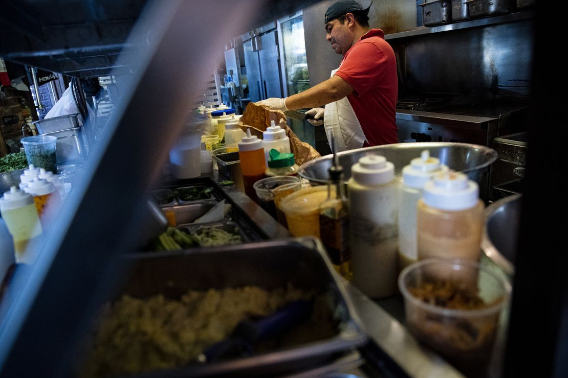 A restaurant worker prepares a sauce at a tavern in Washington, D.C.