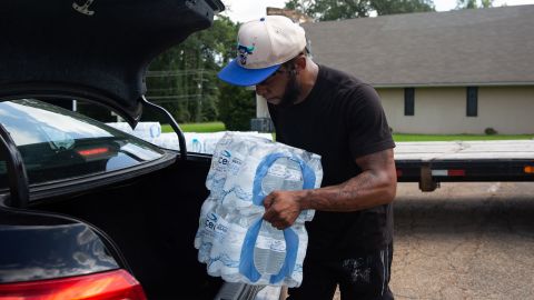 Malcolm Pickett loads water into a resident's car outside of New Jerusalem Church in Jackson, Mississippi, on August 31.