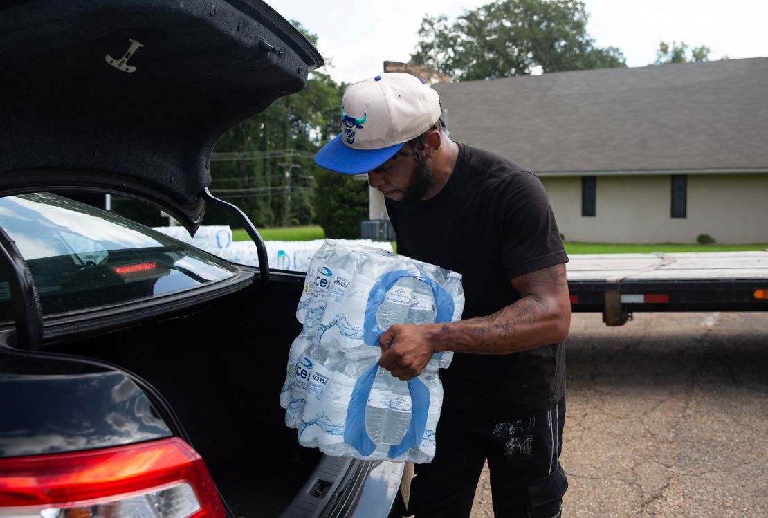 Malcolm Pickett loads water into a resident's car outside of New Jerusalem Church in Jackson, Mississippi, on August 31.