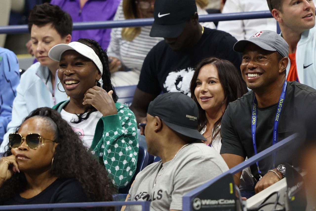 Williams' sister Venus, left, watches Wednesday's match near Woods and his partner, Erica Herman.