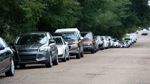 Cars line up Wednesday at a water distribution site at Grove Park Community Center in Jackson, Mississippi.