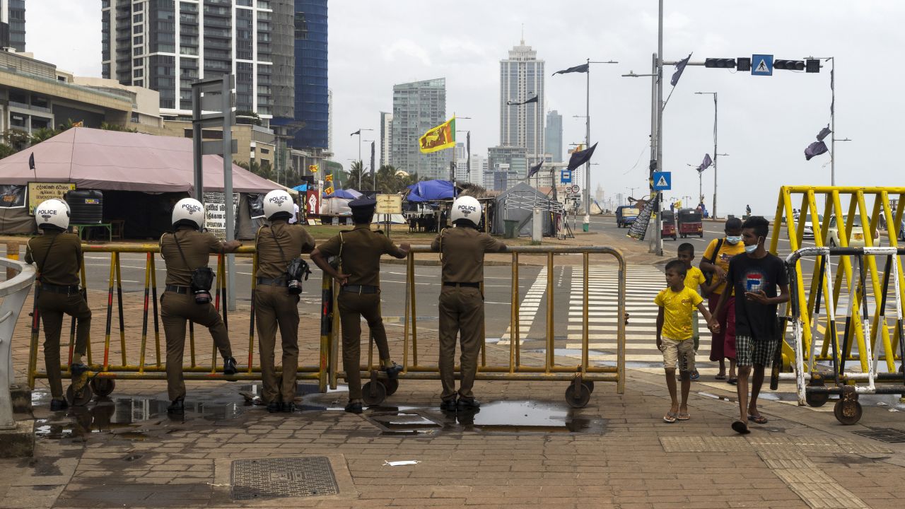 Police officers stand behind the security barricade near a protest camp in Colombo, Sri Lanka, on August 5, 2022