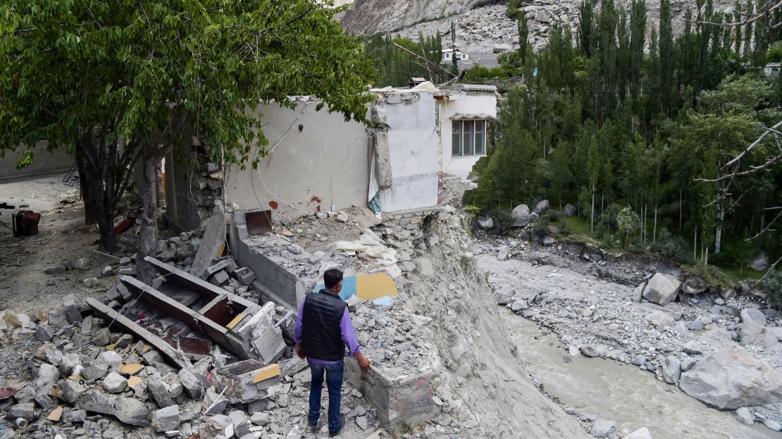 A local resident stands beside his damaged house in June after a glacial lake outburst unleashed catastrophic flooding in the northern Pakistan village of Hassanabad. 