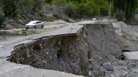 A vehicle drives along a partially collapsed section of Pakistan's Karakoram Highway, damaged after a glacial lake eruption in the Gilgit-Baltistan region.
