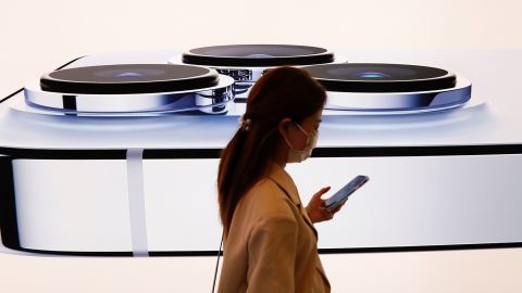 A woman walks past an image of an iPhone 13 Pro at an Apple Store on the day the new Apple iPhone 13 series went on sale, in Beijing, China, on September 24, 2021.