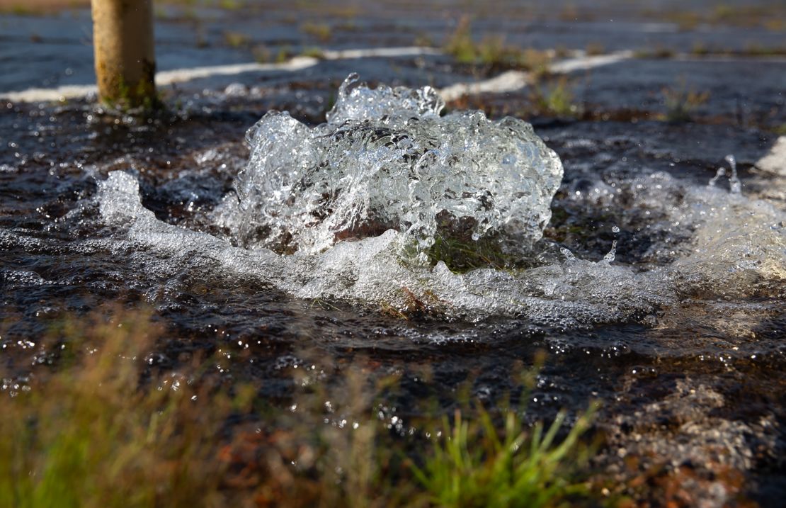 Water spews Thursday from a drain outside of Metrocenter Mall in Jackson, Mississippi.