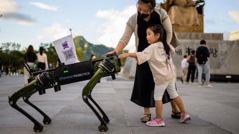 A young girl and her mother interact with a "robot dog" that was made by Ghost Robotics and displayed during an event in Seoul, South Korea, on Wednesday, August 31.