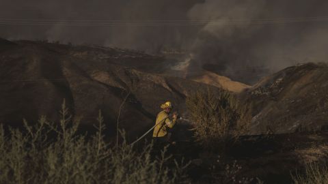 A firefighter hoses down hot spots while battling the Route Fire in Castaic, California, on Wednesday, August 31. <a href="https://www.cnn.com/2022/09/01/weather/route-wildfire-los-angeles-county/index.html" target="_blank">The wildfire</a> began near Castaic Lake and grew so rapidly that a portion of Interstate 5 was shut down in both directions.