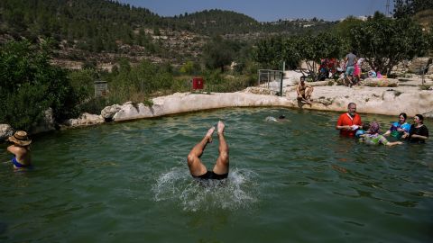 People swim in Jerusalem's Ein Haniya spring during a heat wave on Monday, August 29.