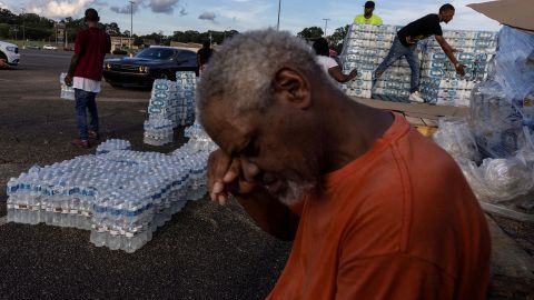 Phillip Young, a resident of Jackson, Mississippi, takes a break while helping local volunteers distribute water bottles in the city on Wednesday, August 31. The state capital has been struggling with a water shortage this week.