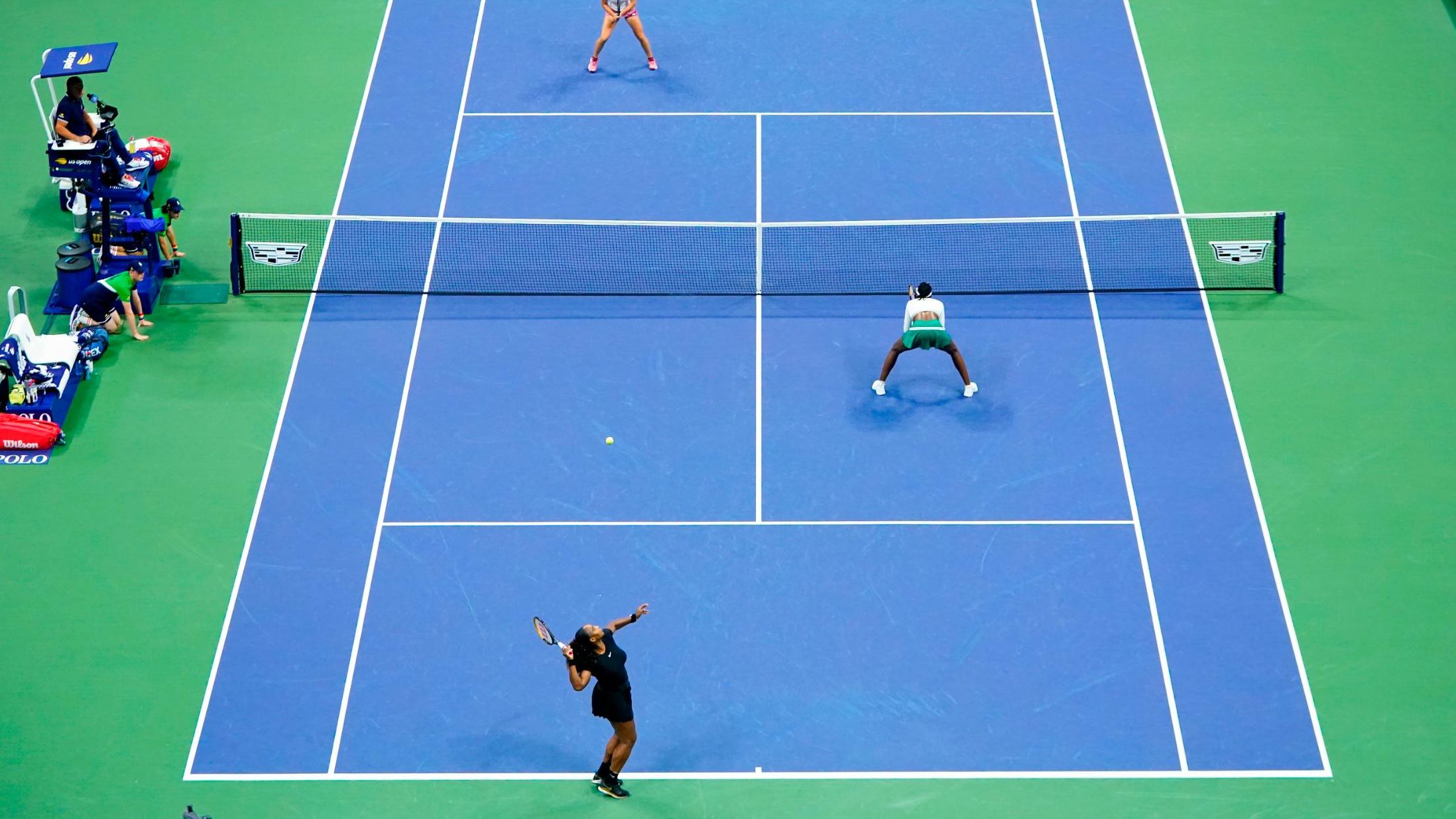 Williams, lower left, serves during Thursday's doubles match.