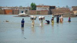 Flood victims wade through flood waters, following rains and floods during the monsoon season, Jafferabad, Pakistan on August 31, 2022.