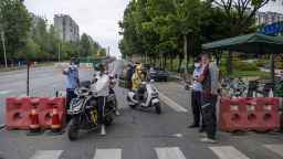 This photo taken on September 1, 2022 shows police officers checking information on a road amid restrictions due to an outbreak of the Covid-19 coronavirus in Chengdu, in China's southwestern Sichuan province. 