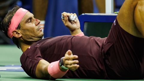 Rafael Nadal receives medical treatment on his nose after hitting himself with his own racket during his match against Fabio Fognini at the US Open.