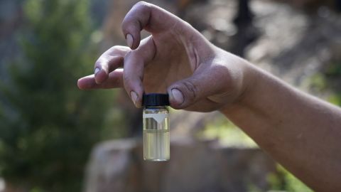 A water treatment plant employee holds up a contaminated water sample from the Gallinas River in August.