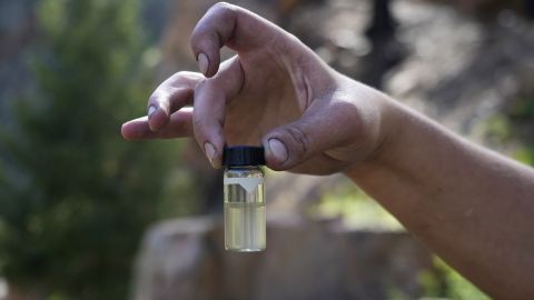 A water treatment plant employee holds up a contaminated water sample from the Gallinas River in early August.