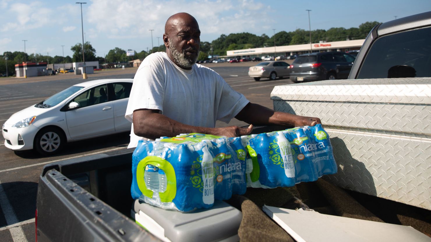 James Taylor places water, that he purchased at Grocery Depot, in his truck bed in Jackson, Mississippi, on August 31, 2022.