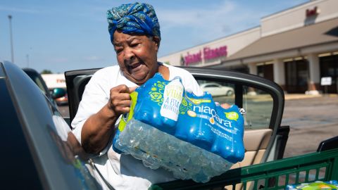 Glenda Johnson places bottled water she purchased at Grocery Depot into her car in Jackson, Mississippi, on August 31.