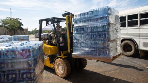 A member of the National Guard lifts water that will later be distributed around Jackson, Mississippi, onto a truck outside Metrocenter Mall on September 1.