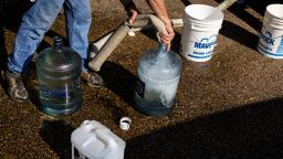 People fill jugs with non-potable water at Forest Hill High School on August 31, 2022 in Jackson, Mississippi.