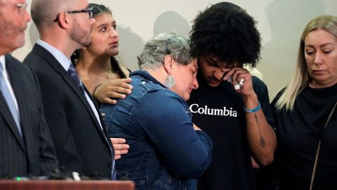 Donovan Lewis' mother Rebecca Duran is embraced as the police body camera footage the deadly shooting is shown at a press conference earlier this week.