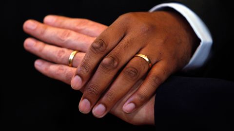 A couple holds hands to pose for a videographer after their wedding ceremony at All Souls Unitarian Church on the first day same-sex couples were legal to wed under a new law on March 9, 2010 in Washington, DC. 