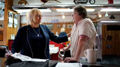 Maine Gov. Janet Mills, left, here chatting with a barber shop owner in Hallowell on May 25, 2022, is being challenged by her predecessor, Republican Paul LePage. 