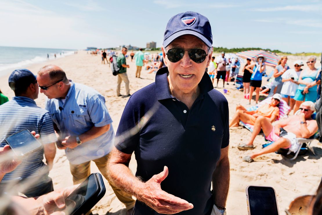 President Joe Biden speaks to reporters as he walks on the beach in Rehoboth Beach, Delaware, on June 20.