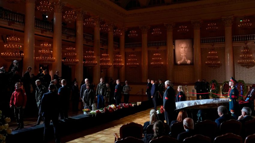 People walk past the coffin of former Soviet President Mikhail Gorbachev inside the Pillar Hall of the House of the Unions during a farewell ceremony in Moscow, Russia, Saturday, Sept. 3, 2022. Gorbachev, who died Tuesday at the age of 91, will be buried at Moscow's Novodevichy cemetery next to his wife, Raisa, following a farewell ceremony at the Pillar Hall of the House of the Unions, an iconic mansion near the Kremlin that has served as the venue for state funerals since Soviet times. (AP Photo/Alexander Zemlianichenko)