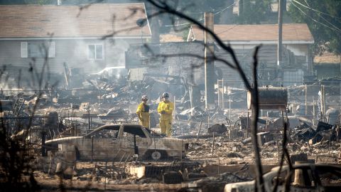 Firefighters survey homes  on Saturday destroyed by the Mill Fire in Weed, California.