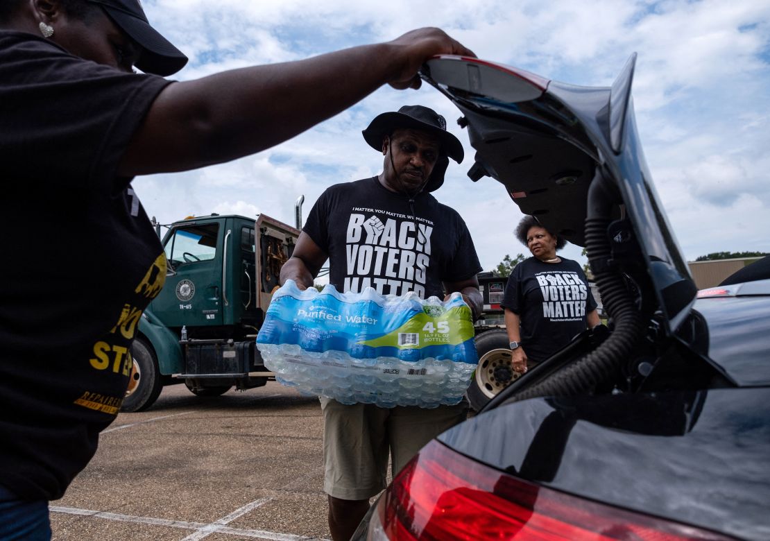 Residents distributed cases of water in Jackson earlier this month. 