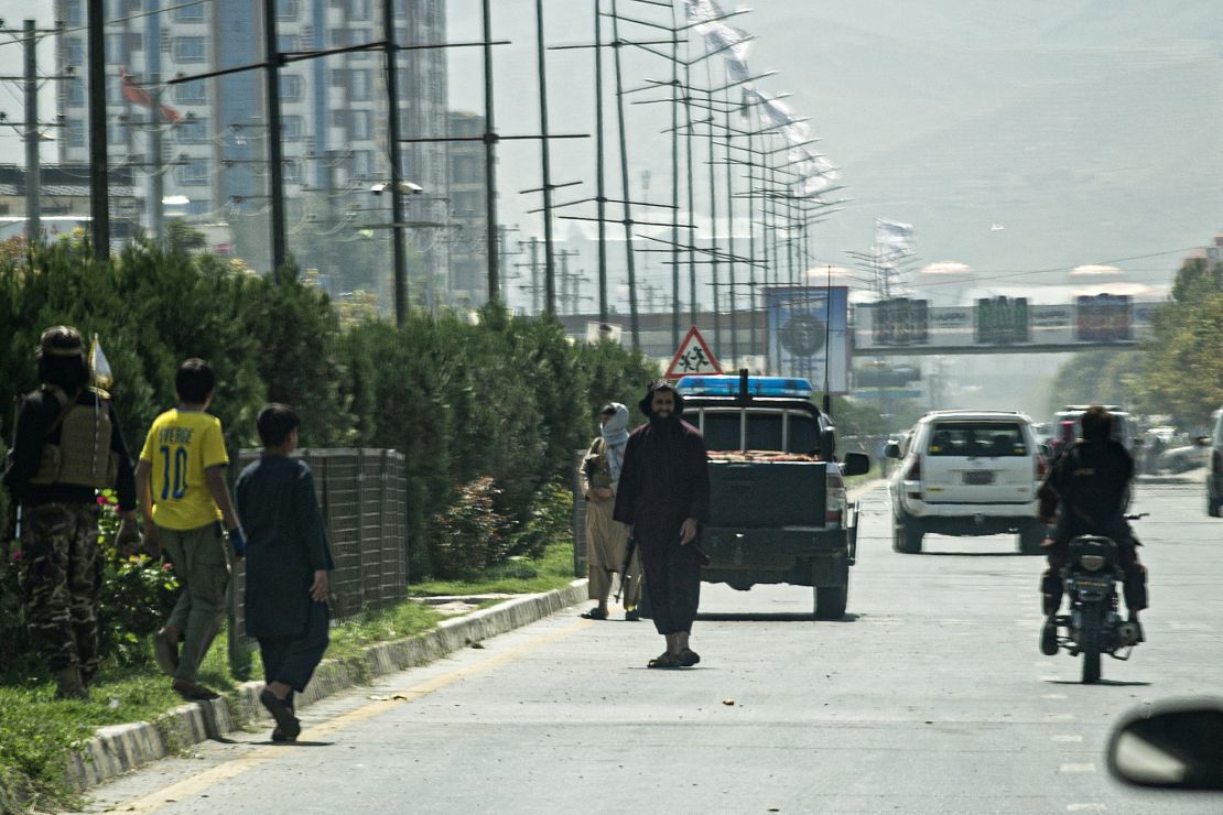 Taliban fighters (C) stand guard along a road near the Russian embassy after the attack on Monday.  