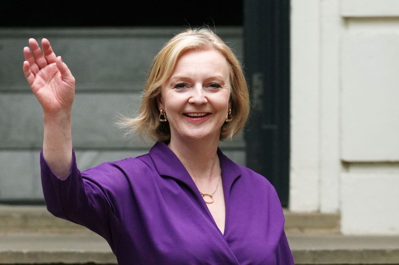 Truss waves as she leaves Conservative Party Headquarters in September 2022.