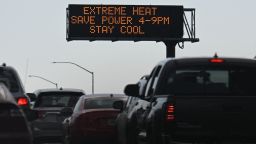 TOPSHOT - Vehicles drive past a sign on the 110 Freeway warning of extreme heat and urging energy conservation during a heat wave in downtown Los Angeles, California on September 2, 2022. - A "dangerous" heat wave has taken hold of the southwestern US. Forecasters said the mercury could reach as high as 112 Fahrenheit (44 Celsius) in the densely populated Los Angeles suburbs as a heat dome settles in over parts of California, Nevada and Arizona. (Photo by Patrick T. FALLON / AFP) (Photo by PATRICK T. FALLON/AFP via Getty Images)