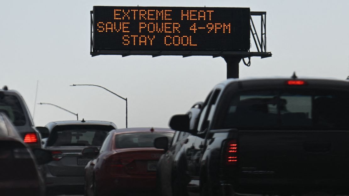 Vehicles drive Friday past a sign on the 110 Freeway warning of extreme heat and urging energy conservation during a heat wave in downtown Los Angeles.