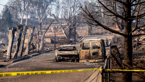 Vehicles and homes destroyed by the Mill Fire line a neighborhood Saturday in Weed, California.