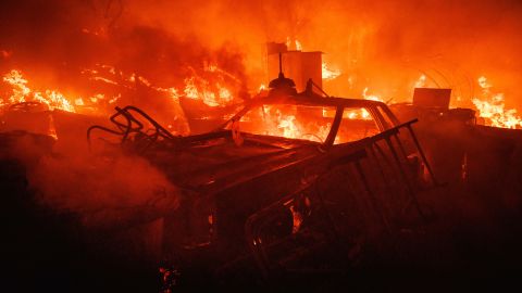 A vehicle burns Monday at a property ravaged by the Fairview Fire near Hemet, California.