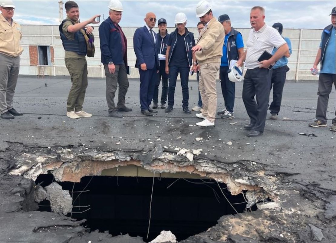 The IAEA team observes the damage caused by shelling on the roof of a building at Zaporizhzhia.