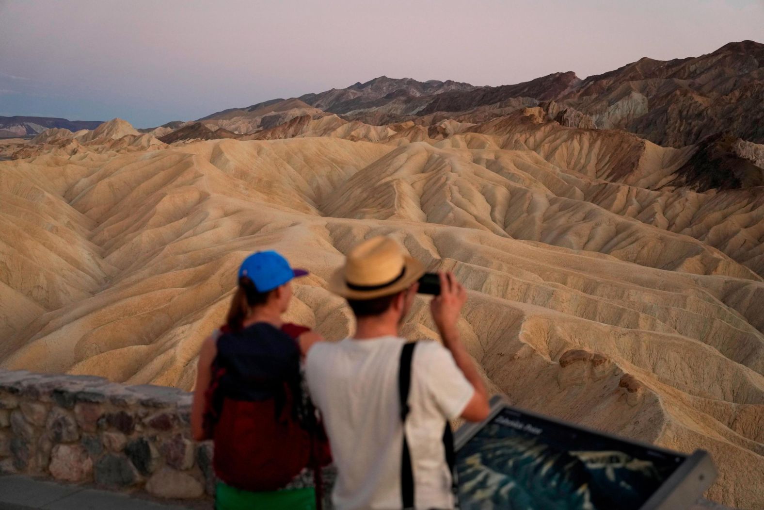 People visit Zabriskie Point in Death Valley National Park as the sun sets on September 1.