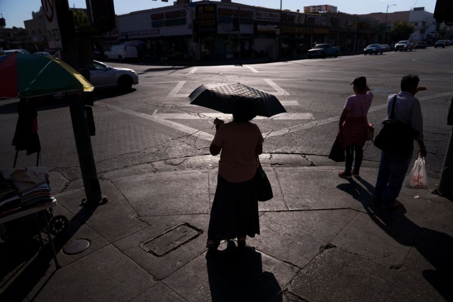 A pedestrian in Los Angeles uses an umbrella to block the sun on September 1.