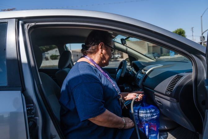 A woman fills up a water jug at a water station in El Centro, California, on August 31.
