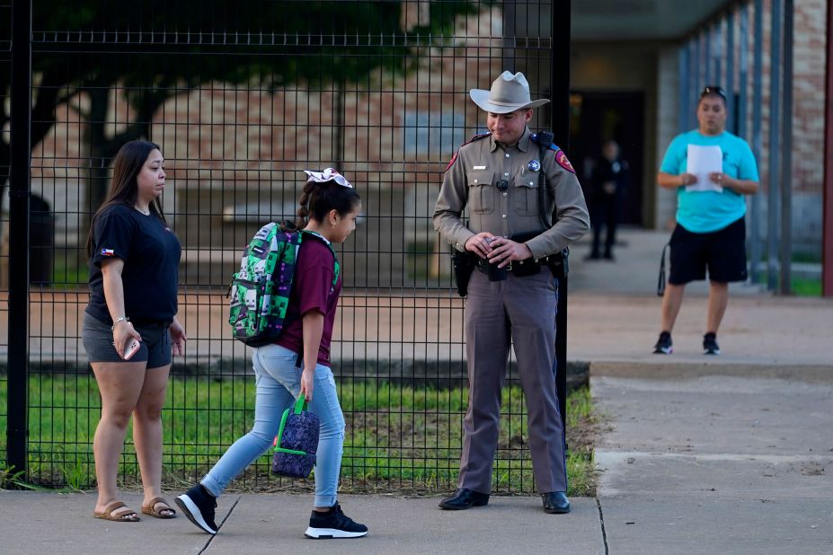 Students arrive at Uvalde Elementary, which was protected by a fence and Texas state troopers on Tuesday.