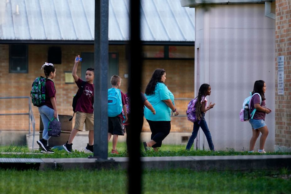 Students are escorted into Uvalde Elementary on Tuesday.