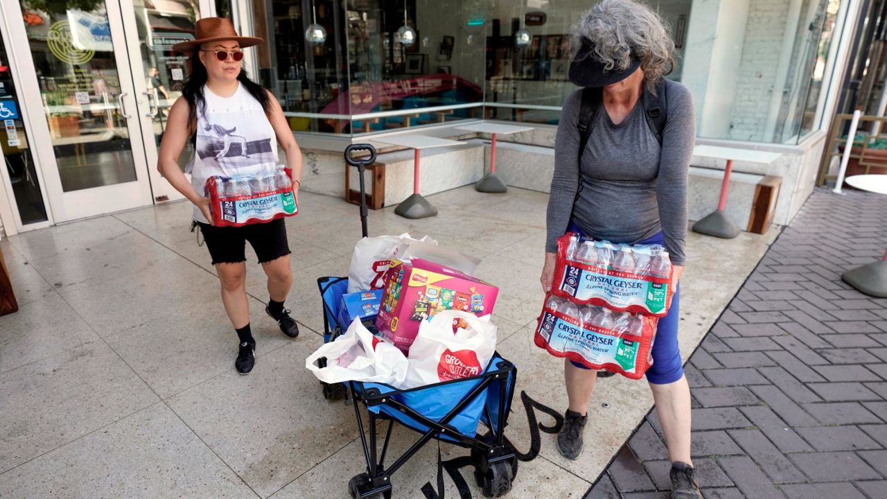 Debbie Chang, left, and Kim Burrell load bottled water into a cart to be distributed to people on the street in Sacramento on Tuesday.