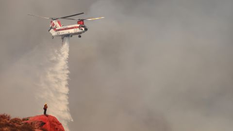 Un hélicoptère de lutte contre les incendies largue de l'eau alors que l'incendie de Fairview brûle mardi près de Hemet, en Californie. 