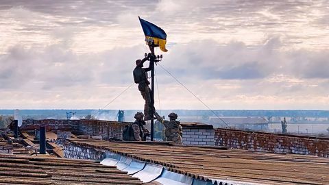 Ukrainian troops hoist flag above building in Vysokopillya, in southern Kherson region.