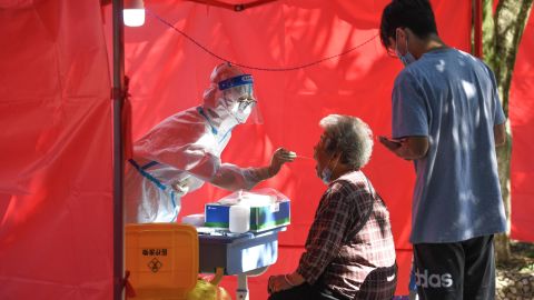 A medical worker takes a swab sample from a resident for nucleic acid testing at a community testing site for COVID-19 in Yunyang District, Guiyang city, southwest China's Guizhou province, September 5, 2022 .