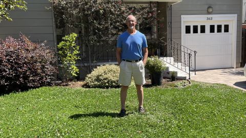 Christian Vessier on the front lawn -- where the lawn has been replaced with a low-water ground cover. 